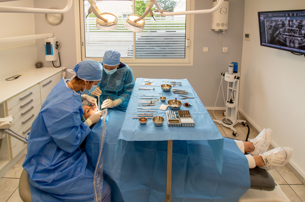 Docteur Stéphanie Henriques qui effectue une pose d'implant. dans un bloc opératoire